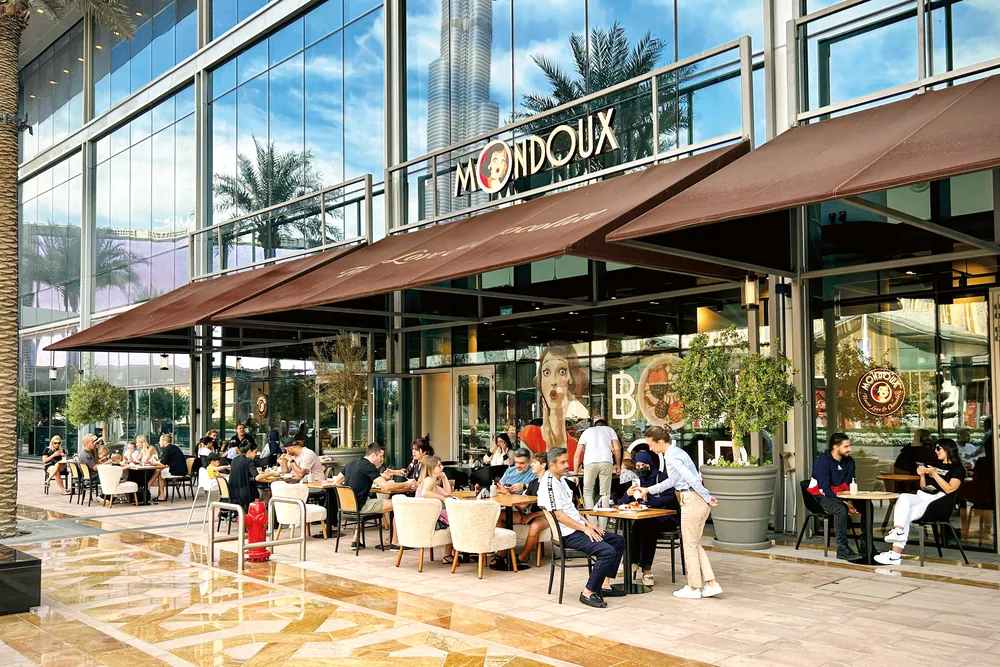 Lively outdoor terrace at Mondoux Dubai Mall with Burj Khalifa behind