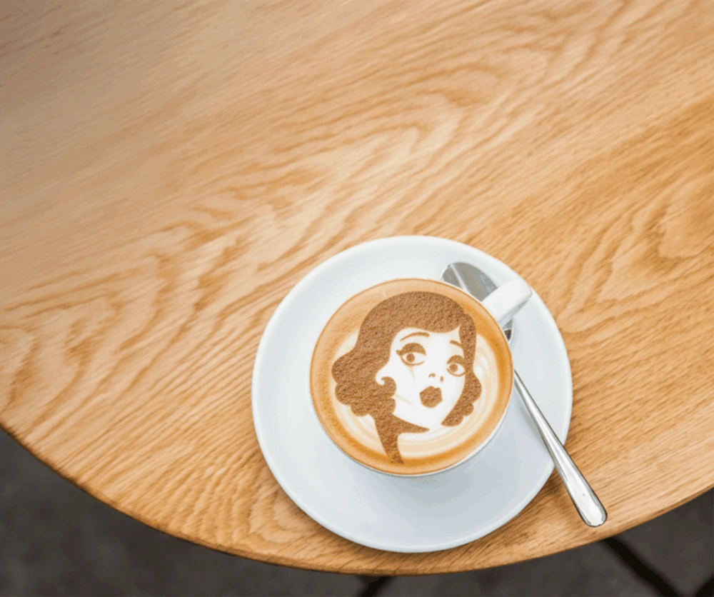 Mondieu signature coffee art on a wooden table at Eurovea