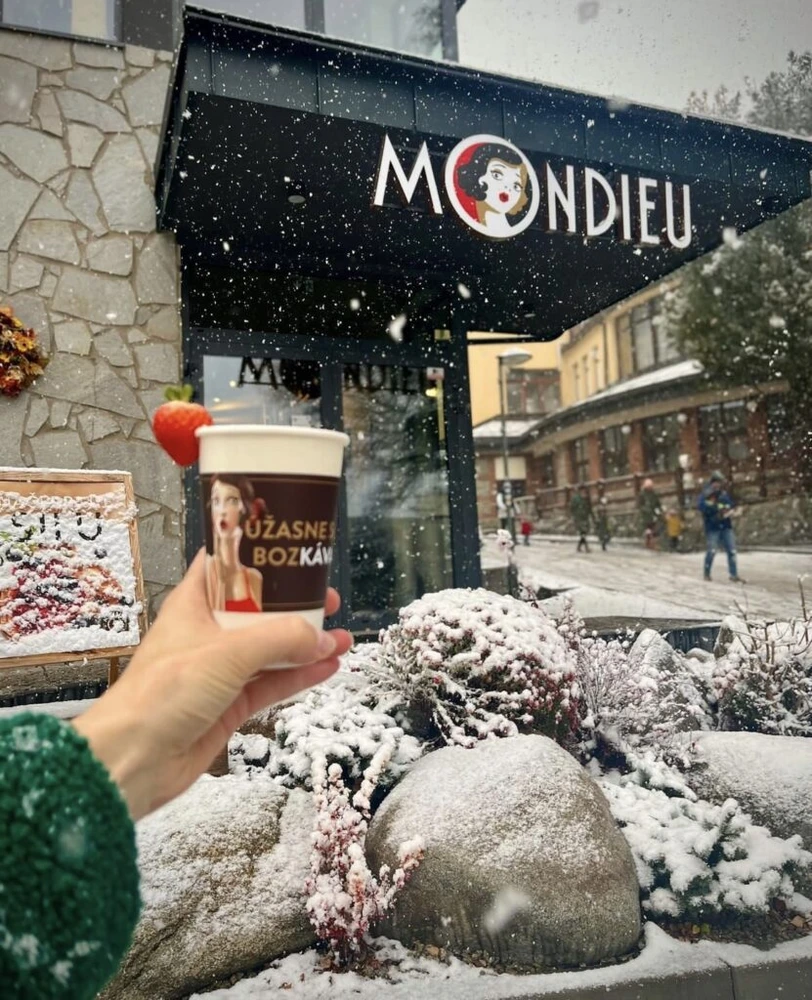Mondieu takeaway coffee outside the snowy Starý Smokovec café